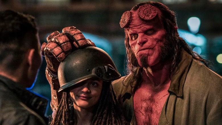 Hellboy holding a helmet on top of Alice Monaghan's head in "Hellboy"