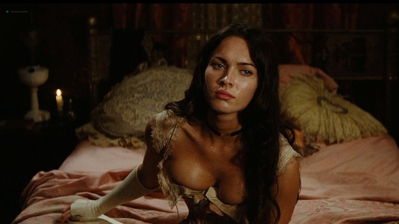 Megan Fox sits on bed