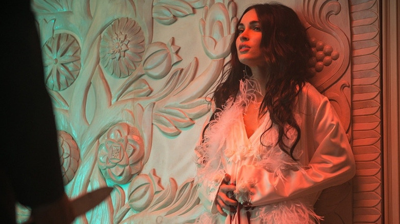 Megan Fox leans against wall