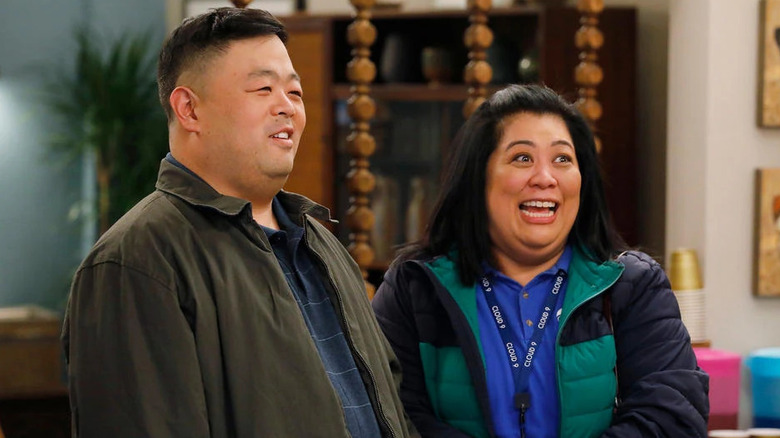 Jerry and Sandra standing together in outerwear on "Superstore" (2015-2021)