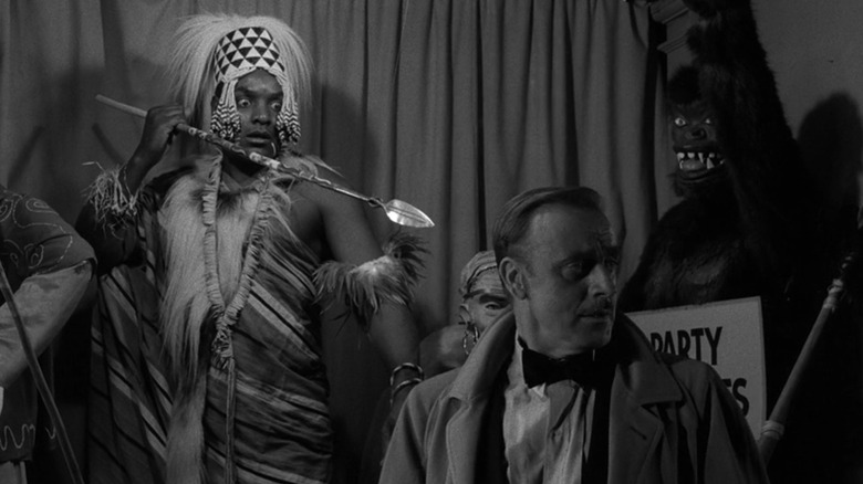 A tribal mannequin with wide eyes points a spear at John Dehner as Alan in "The Jungle" from "The Twilight Zone."