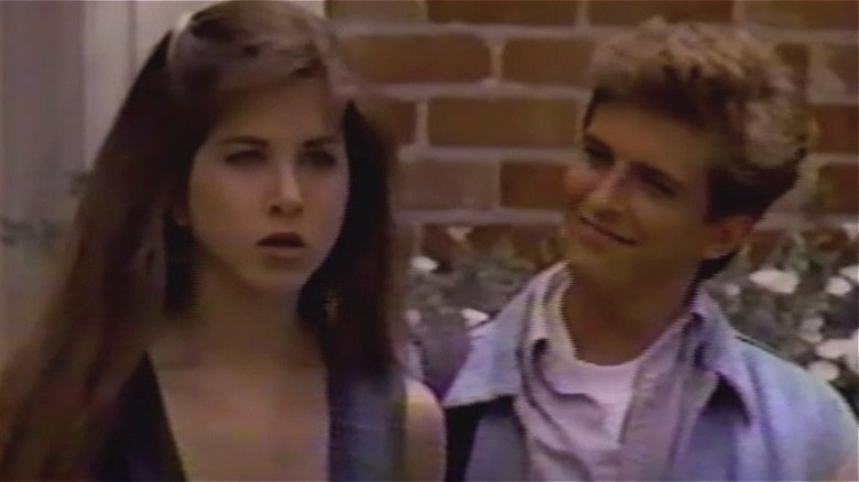 Ferris Bueller looking at Jeannie Bueller with a smirk in Ferris Bueller (1990)