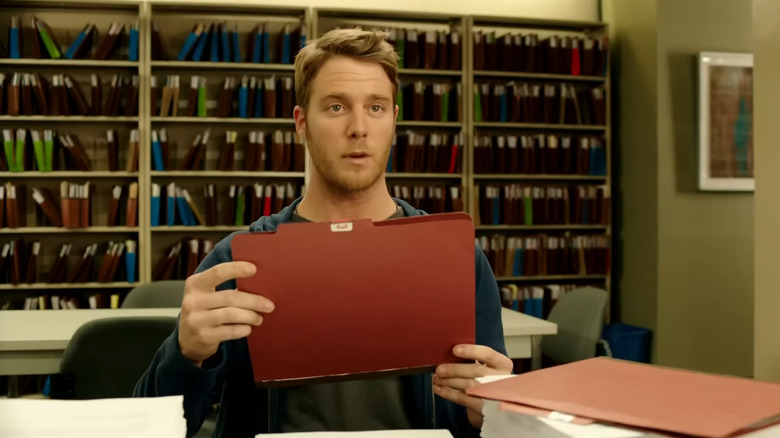 Brian Finch holding a file in Limitless