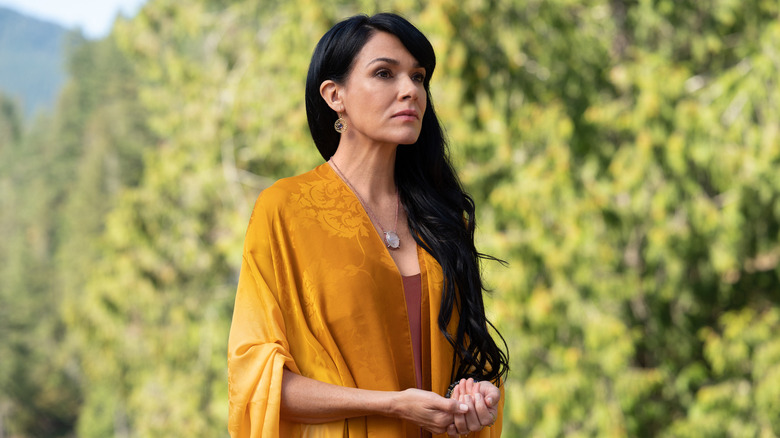 Adult Lottie stands in orange shawl  