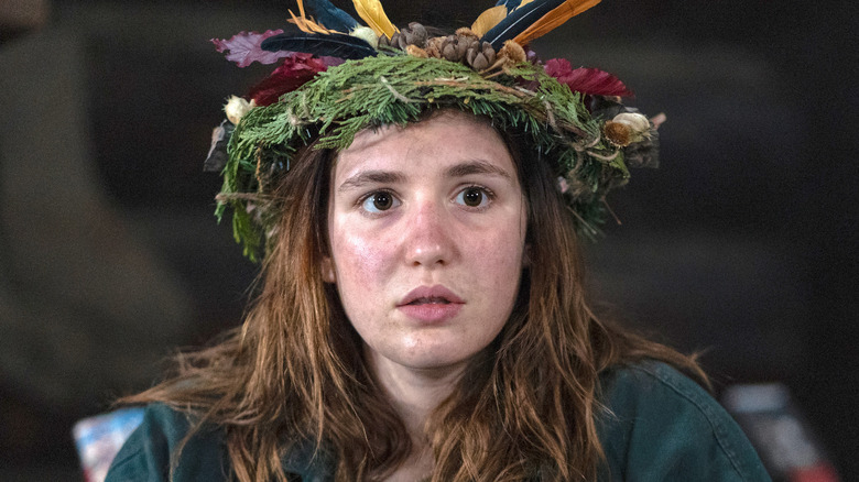 Shauna sits in feather headcrown 