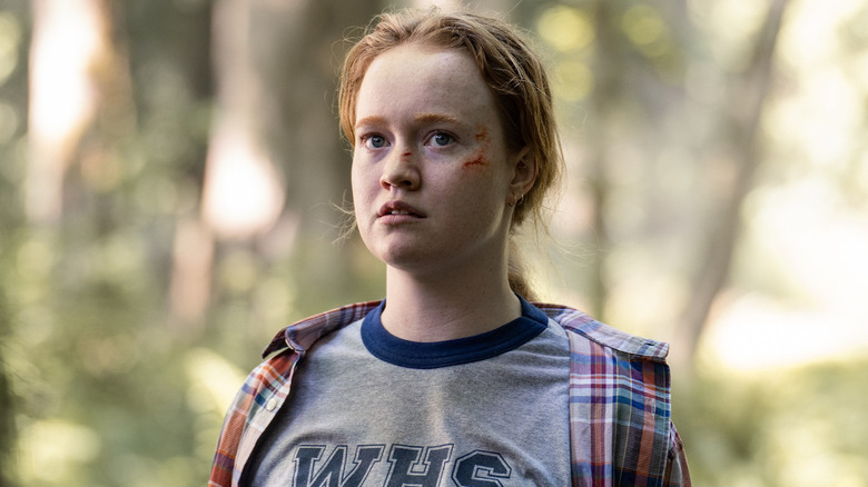 Teen Van stands in woods 