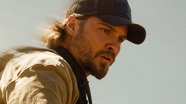 A concerned-looking Kayce Dutton rides with the sky behind him in 