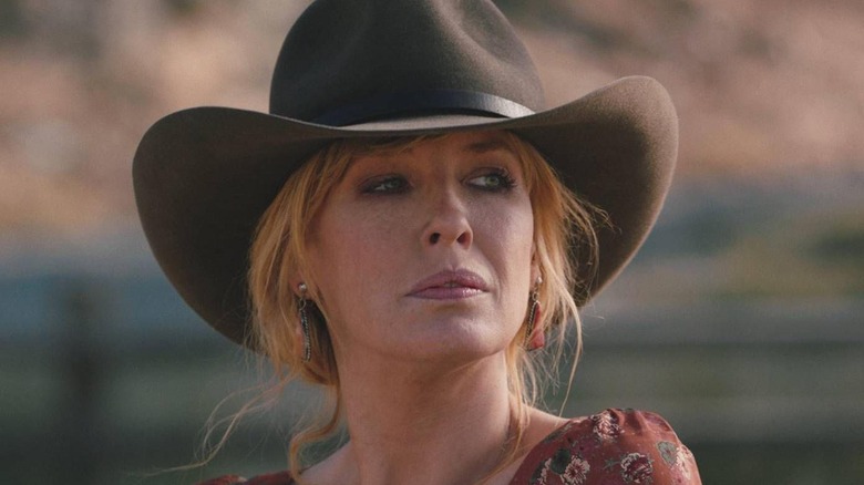 Beth in a cowboy hat looks into the distance in Yellowstone