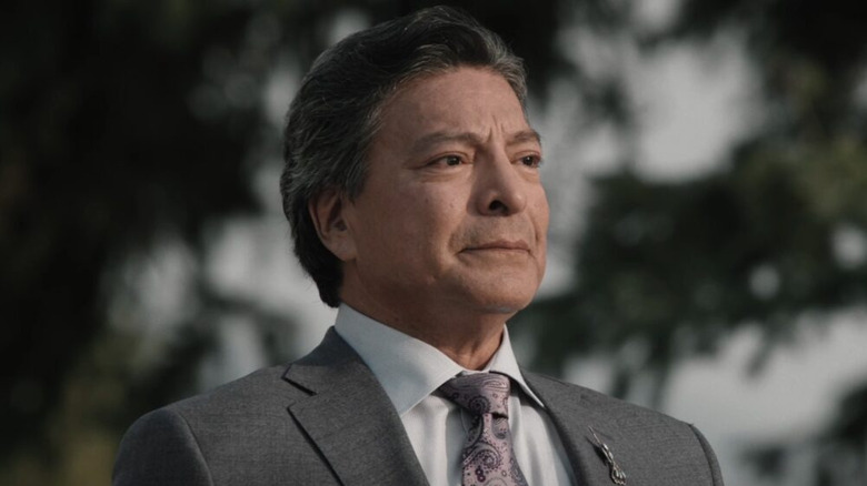 Thomas Rainwater wearing a suit and listening in "Yellowstone"