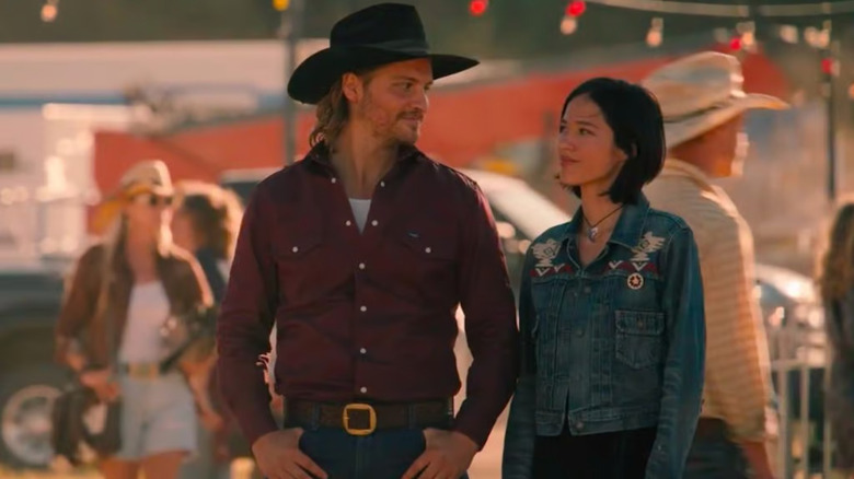 Kayce and Monica walk around the festival in "Yellowstone"