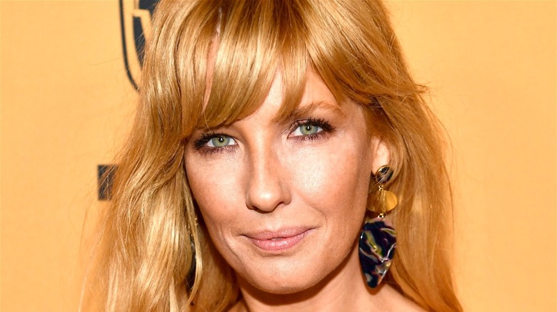 Yellowstone star Kelly Reilly smiling orange background