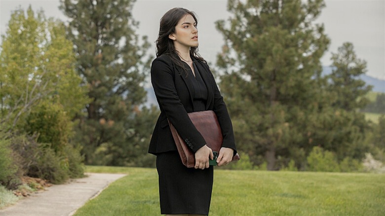 Clara holding a satchel outside