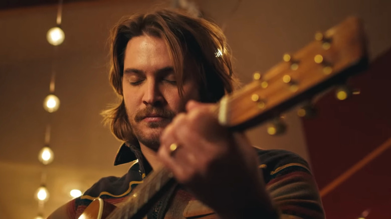 Luke Grimes playing guitar