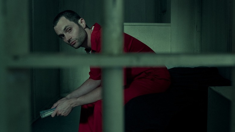 An incarcerated Joe holding a book