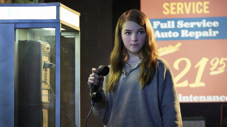 Missy standing at a pay phone