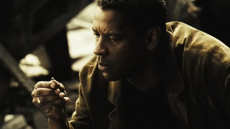 Carlin examines a piece of evidence found at a crime scene in Deja Vu