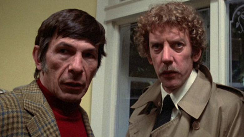 Kibner and Bennell stand in front of a window in Invasion of the Body Snatchers