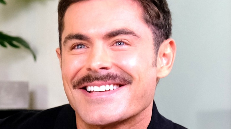 Zac Efron smiles with mustache
