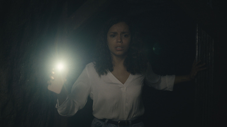 Tess with phone light in Barbarian