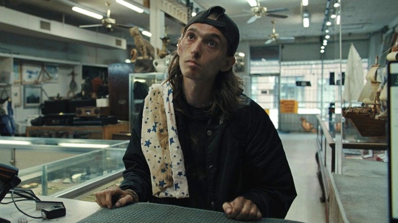 James standing in the pawn shop in Weapons