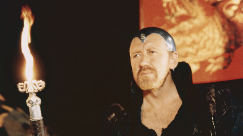 Merlin holding a staff of fire in Excalibur (1981)