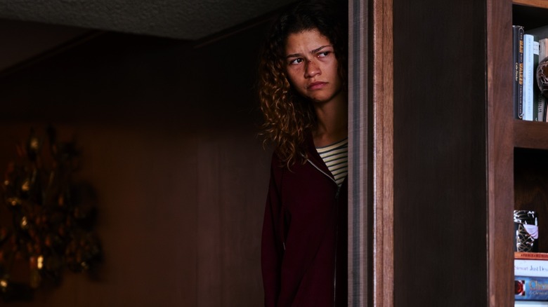 Rue peeking around a door with a bloody nose on Euphoria