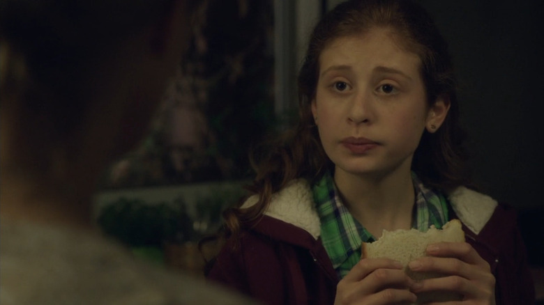 Camille holding a sandwich on The Returned